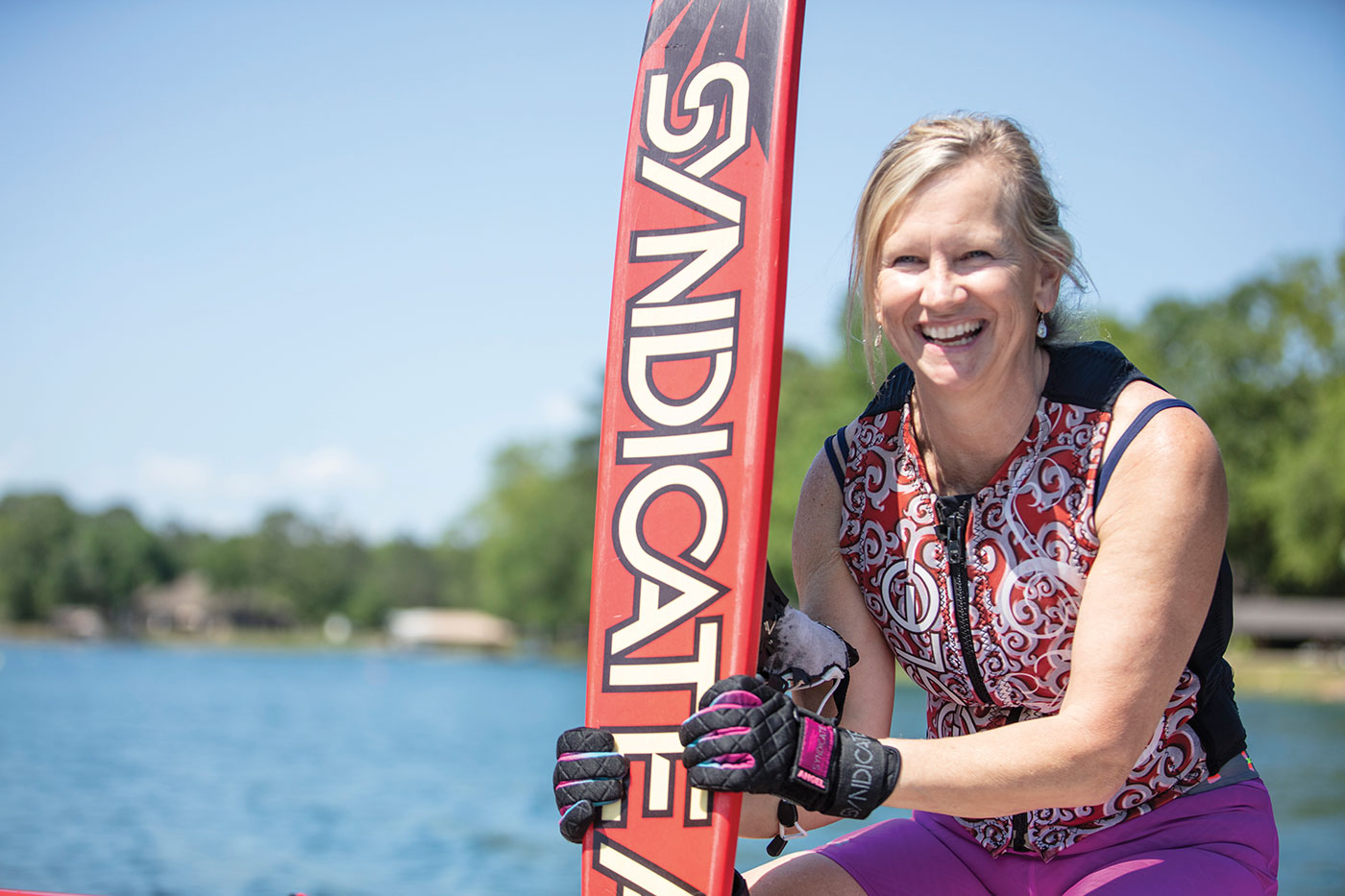 Woman holding a water ski by the lake
